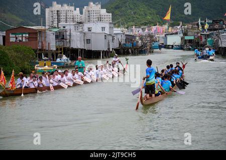 A vertical closeup of people riding on boats at the Dragon Boat Festival in Tai O, Hong Kong Stock Photo