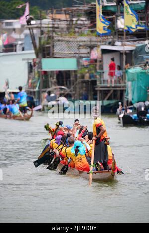 A closeup of People riding dragon boats at the Dragon Boat Festival in Tai O, Hong Kong Stock Photo