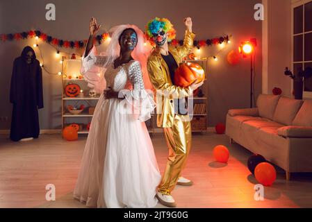 Two happy friends dressed in Dead Bride and Clown outfits having fun at Halloween party Stock Photo