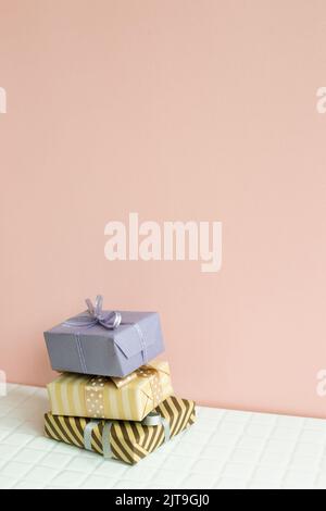 Colorful gift boxes on white table. pink wall background Stock Photo
