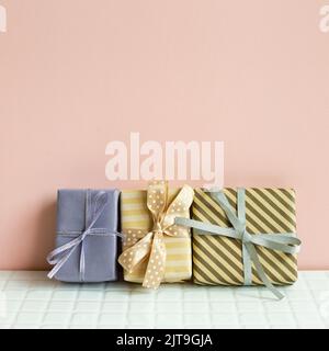 Colorful gift boxes on white table. pink wall background Stock Photo