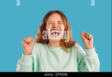 Portrait of funny young woman or teen girl laughing or screaming with mouth wide open Stock Photo