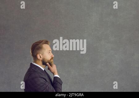 Thinking puzzled confused uncertain businessman looking forward at copy space Stock Photo
