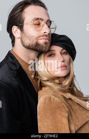 portrait of stylish couple in beret and sunglasses posing isolated on grey,stock image Stock Photo