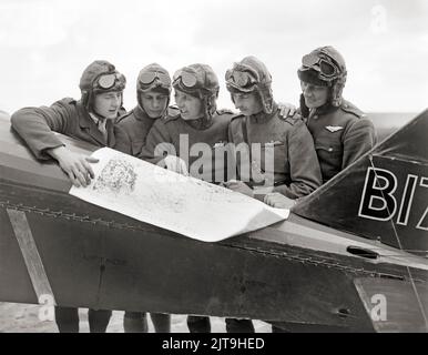 Multi-national pilots of No. 32 Squadron conferring on the tail of a Royal Aircraft Factory S.E.5A  fighter biplane. An American, Canadian, New Zealander, Englishman and South African, respectively; Green, Lawson, Leese, McBean, Hooper. Humieres aerodrome, near St. Pol, 15 May 1918 Stock Photo