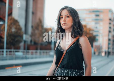 A Caucasian female model waiting at a bus station Stock Photo