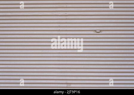 Grey vintage striped door, closeup of garage steel wall texture, horizontal lines pattern, background. Stock Photo