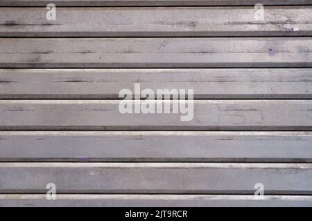Dirty garage steel wall, closeup, grunge texture and pattern, grey vintage horizontal striped door, background. Stock Photo
