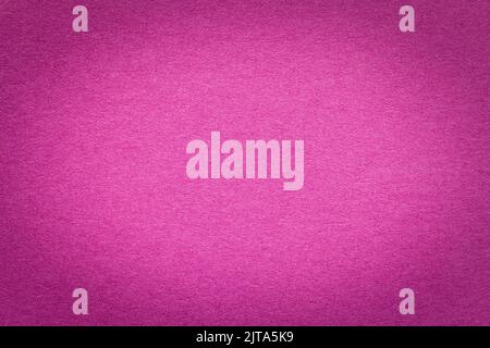 Texture of vintage purple paper gradient background with dark vignette. Structure of dense craft magenta cardboard with frame. Felt backdrop with bord Stock Photo
