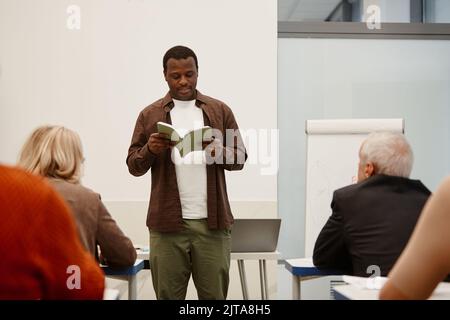 African teacher reading a lecture for adult students during training in class Stock Photo