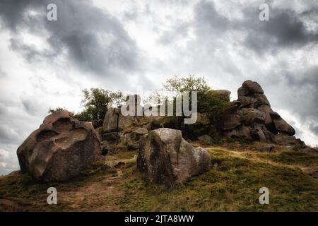 The massive rocks on the top of a hill against the background of the cloudy sky. Robin Hood's Stride. Stock Photo