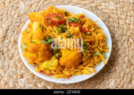 Indian vegetarian fried rice in the plate with carrot, spring onion, green peas, colliflower Stock Photo