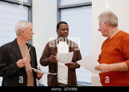 African teacher talking to his senior students after lesson, they standing at corridor and discussing their achievements Stock Photo