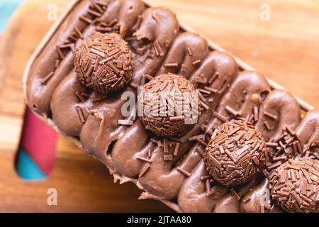 Cake called Brigadeiro Caseirinho. Chocolate cake with chocolate frosting and brigadiers to decorate. Confectionery, dessert. Stock Photo