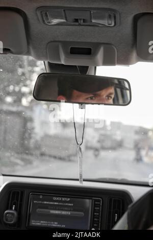 Man driving a car face in front mirror Stock Photo