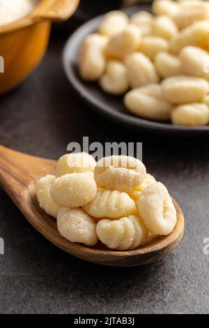 Uncooked potato gnocchi on a wooden spoon. Tasty italian food. Stock Photo