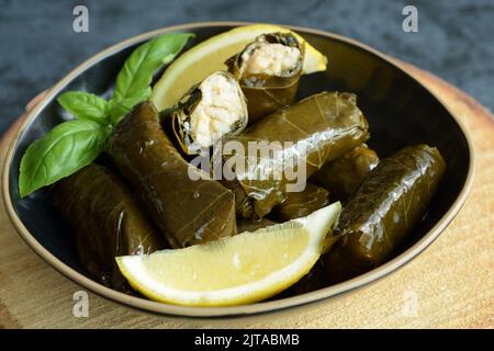 Grape leaf filled with rice served with lemon. Traditional Greek food Stock Photo