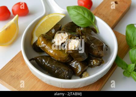 Grape leaf filled with rice served with lemon. Traditional Greek food Stock Photo