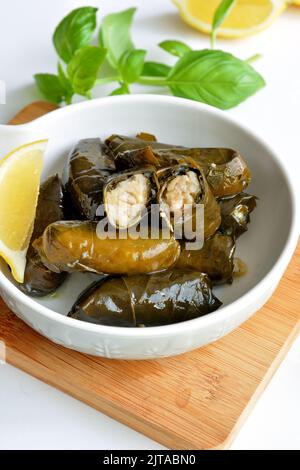 Grape leaf filled with rice served with lemon. Traditional Greek food Stock Photo