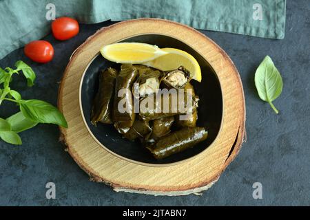 Grape leaf filled with rice served with lemon. Traditional Greek food Stock Photo