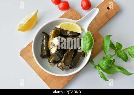 Grape leaf filled with rice served with lemon. Traditional Greek food Stock Photo