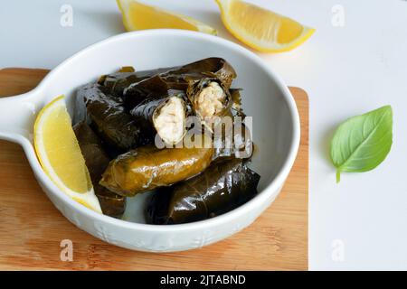 Grape leaf filled with rice served with lemon. Traditional Greek food Stock Photo