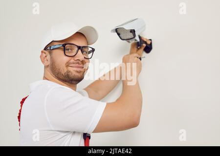 Portrait of smiling male technician worker who installing video surveillance camera. Stock Photo