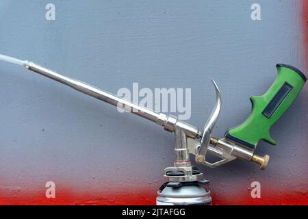 mounting foam gun and foam cylinder on the shelf in the workshop Stock Photo