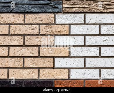 Texture of a wall covered with decorative brick-like tiles. Abstract background for design. Stock Photo