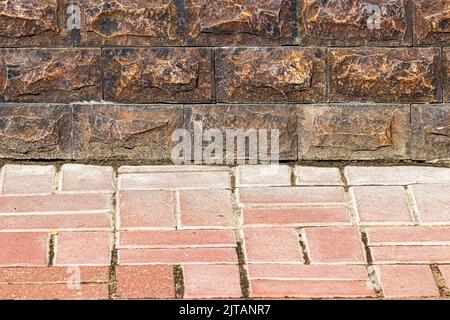 Texture of a wall covered with decorative brick-like tiles and pavement. Abstract background for design. Stock Photo