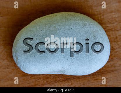 Scorpio zodiac sign text engraved on a stock with wooden background. Zodiac sign concept. Stock Photo