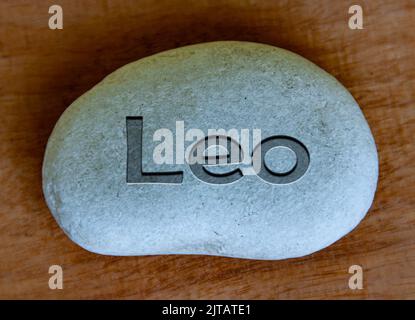 Leo zodiac sign text engraved on a stock with wooden background. Zodiac sign concept. Stock Photo