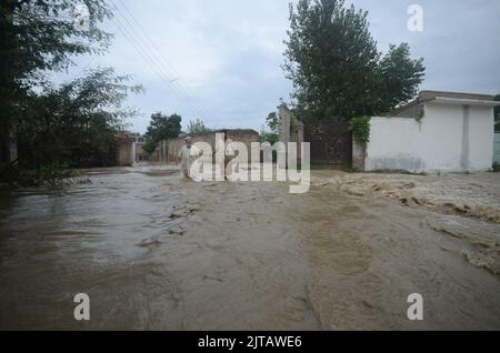 Peshawar, Pakistan. 26th Aug, 2022. Torrential rains and storms cause flooding in Pakistan. Downpours and severe storms affected life in the Dagai Mukaram Khan region, near the city of Peshawar. Citizens made their way through the flooded streets with difficulty. (Credit Image: © Rana Sajid Hussain/Pacific Press via ZUMA Press Wire) Stock Photo