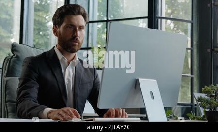 Caucasian busy serious bearded middle-aged 40s man worker in office working online commerce service trade in internet. Adult manager company CEO Stock Photo