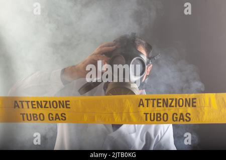A medical engineer wearing antigas mask experienced in the gas leaks crisis directing the emergency during the chaos. On the yellow tape the written n Stock Photo