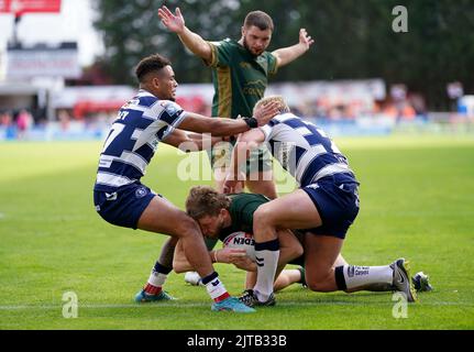 Hull Kingston Rovers' Ethan Ryan (centre) scores a try, but takes a knee in the face from Wigan Warriors' Umyla Hanley (left) during the Betfred Super League match at the Sewell Group Craven Park, Kingston upon Hull. Picture date: Monday August 29, 2022. Stock Photo