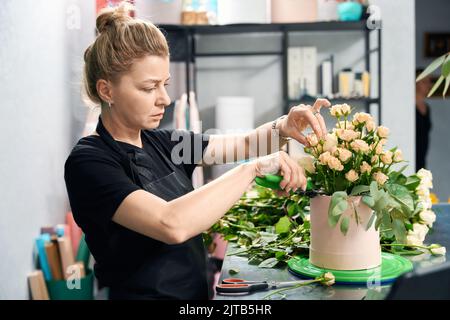 Florist making beautiful flower composition while working in flower shop Stock Photo