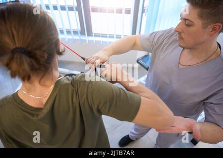 Physiotherapist conducts session of physiotherapy exercises on a power simulator Stock Photo