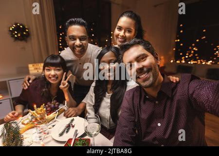 friends taking selfie on christmas dinner at home Stock Photo