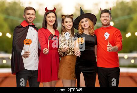 friends in halloween costumes with party props Stock Photo