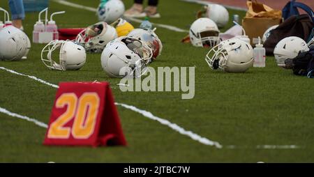 Helmets for american football on green grass. Team sport concept Stock Photo