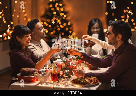 happy friends drinking wine at christmas party Stock Photo