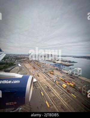 A jet blue plane preparing to land in Boston United States on a cloudy sunny day Stock Photo
