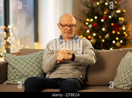 senior man looking at wristwatch on christmas Stock Photo