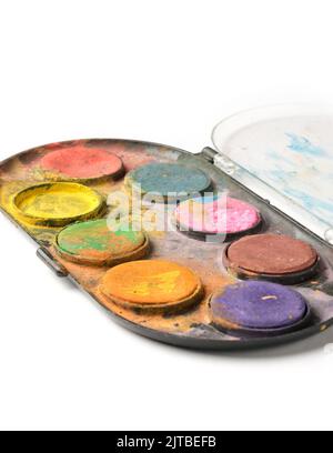 close-up of used and dirty box of watercolor paints, isolated on white background, selective soft-focus, artist workplace concept Stock Photo