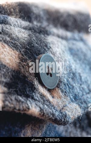 Button on a warm blue shirt, macro shot. Stock Photo