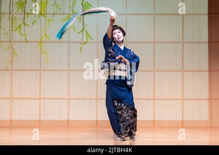 A Japanese geisha wearing a kimono, performs a traditional dance called the Dance of the Scarves at the Kanda Myojin Shrine, in Chiyoda, Tokyo, Japan. Stock Photo