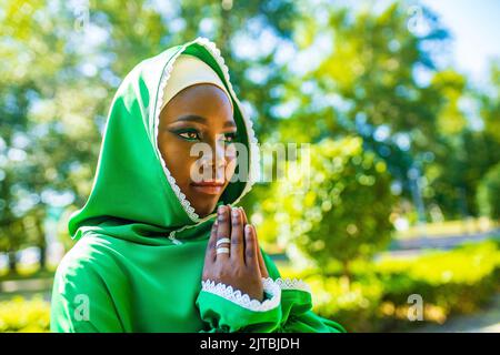 Beautiful modern student woman in hijab with make-up and piercing ring on the nose outdoor Stock Photo