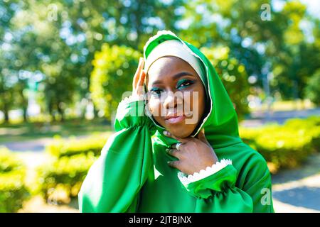 Beautiful modern student woman in hijab with make-up and piercing ring on the nose outdoor Stock Photo