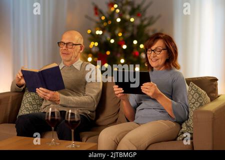 senior couple with book and tablet pc on christmas Stock Photo